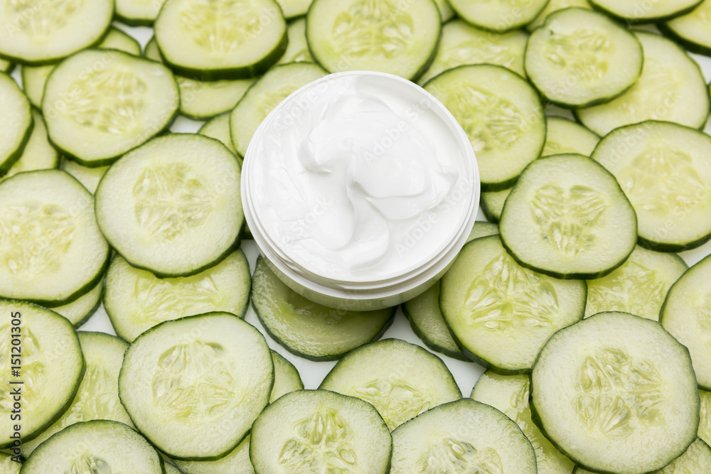 Top view of facial cream in container and cucumber slices Top view of facial cream in container and cucumber slices
