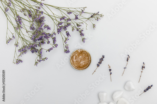 Top view of organic cream in container and dried lavender isolated on white