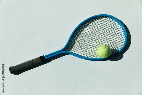 tennis racket and ball on the floor at room with daylight