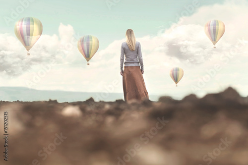 Bilde på lerret Dreamy woman looks at the hot air balloons coming down