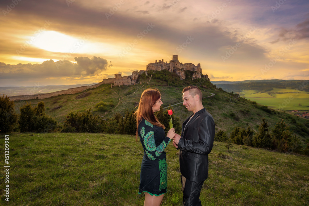Young couple in love at sunset near a ruined castle Young couple in love at sunset near a ruined castle