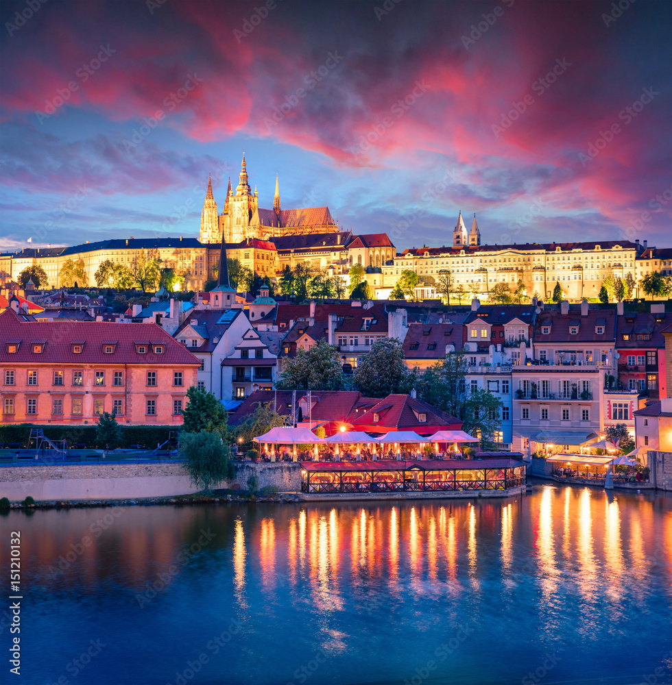 Colorful evening view from Charles Bridge of Prague Castle and St. Vitus cathedral on Vltava river.