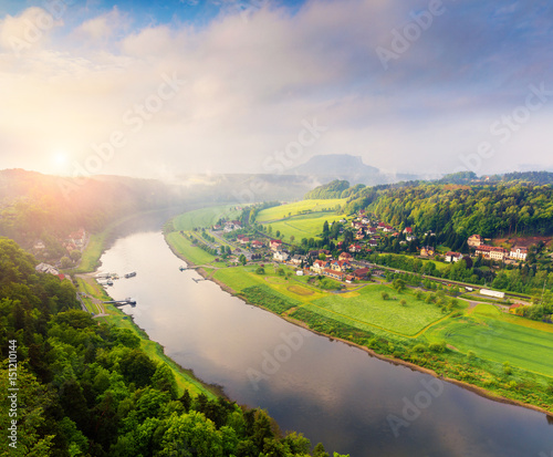 Foggy spring view of Rathen village from viewpoint of Bastei in Saxon Switzerland Germany. © Andrew Mayovskyy