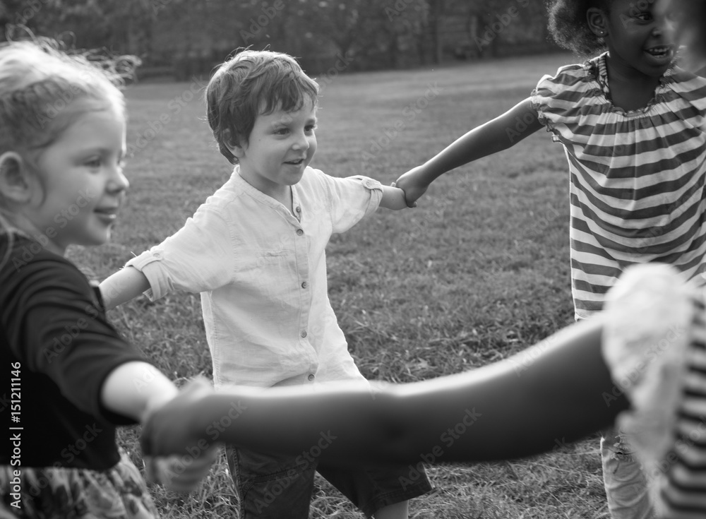 Fototapeta premium Group of kindergarten kids friends holding hands playing at park