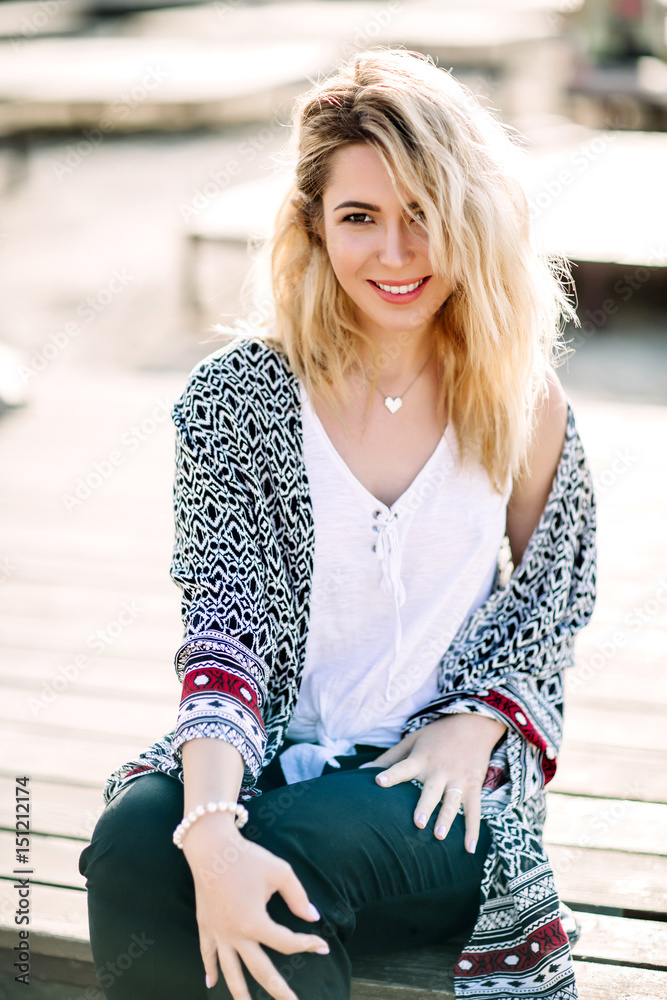 Blonde girl on the beach of the sandy beach by the sea