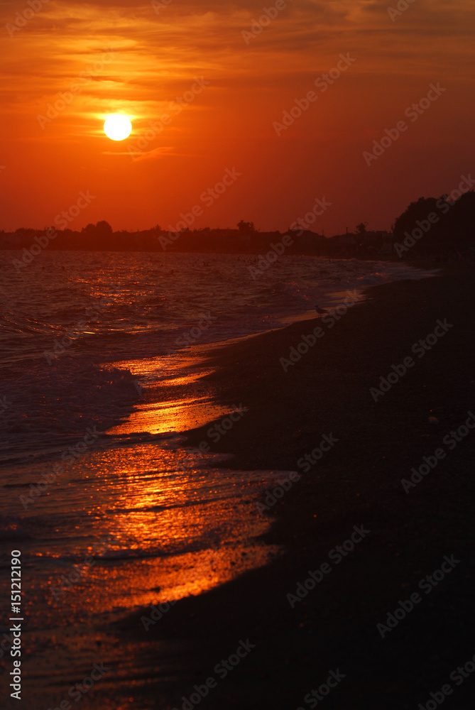 Beautiful red sunset landscape on the beach. Big orange sun on the horizon