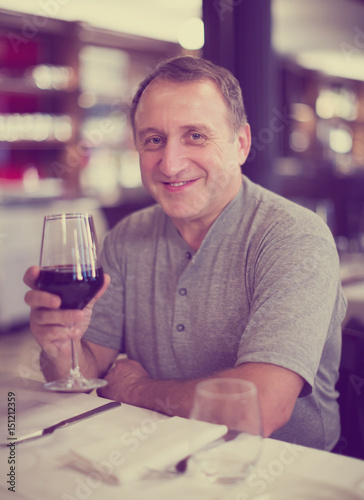 Man sits restaurant with wineglass
