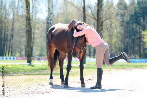 Young cheerful teenage girl owner hugging her favorite horse © AnnaElizabeth