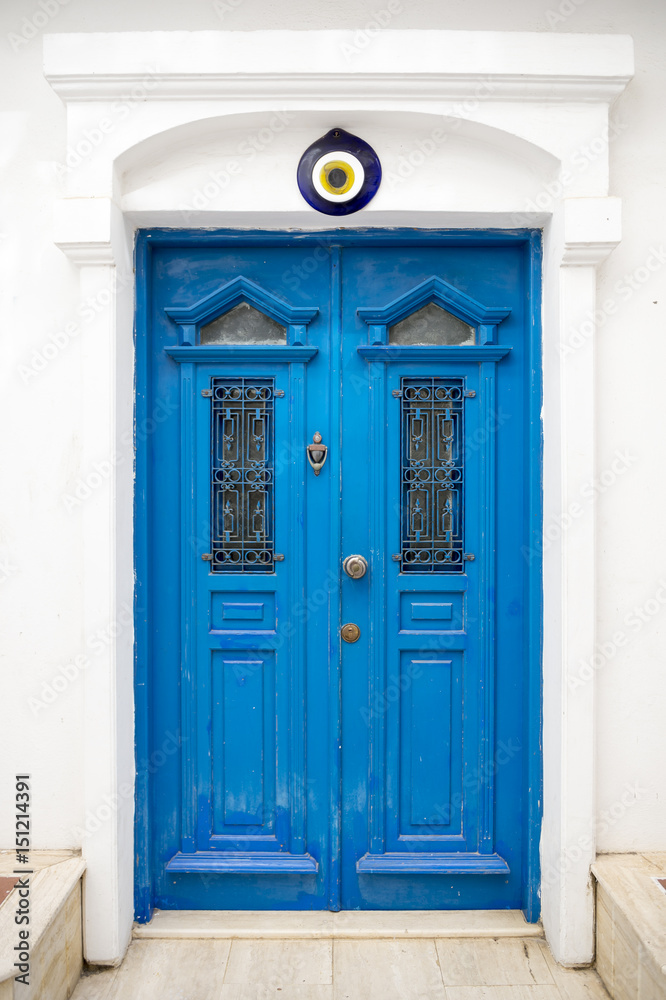 Traditional Mediterranean blue and white door featuring a Turkish evil eye protection 
