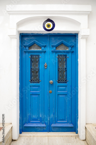 Traditional Mediterranean blue and white door featuring a Turkish evil eye protection  nazar  medallion on the top of the doorway