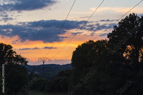 Sunset over valley with overhead power lines
