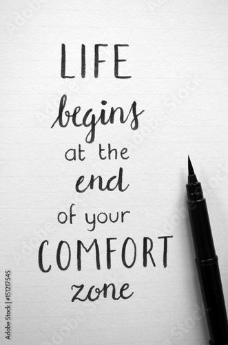 LIFE BEGINS AT THE END OF YOUR COMFORT ZONE written in brush calligraphy on notepad photo