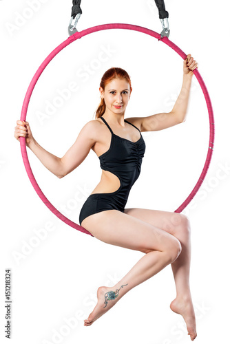 Gymnast on an air ring on a white background in a black swimsuit poses © kosmos111