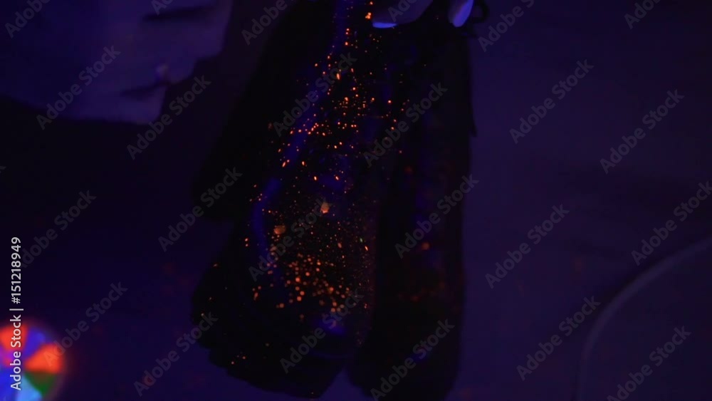Splashes of neon paint in slow motion on woman's boots with high heels. Splashes of neon paint in slow motion on woman's boots with high heels.