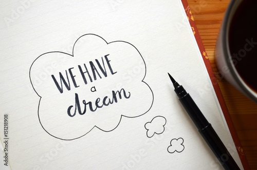Canvas-taulu WE HAVE A DREAM written in notepad on desk with cup of coffee