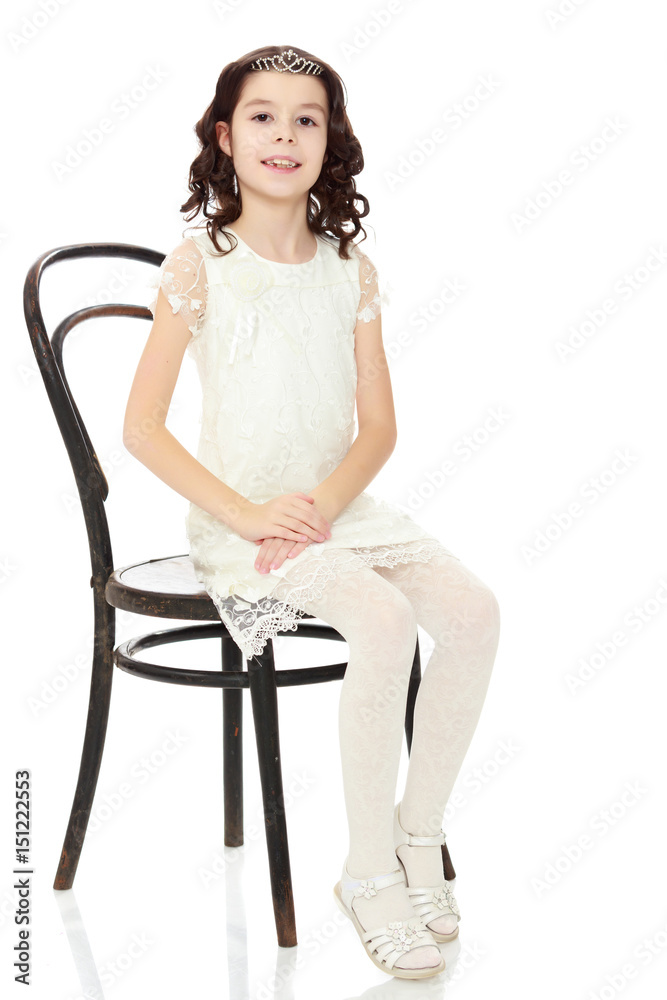 Fototapeta premium Slender little dancer posing near the old Vienna chair.