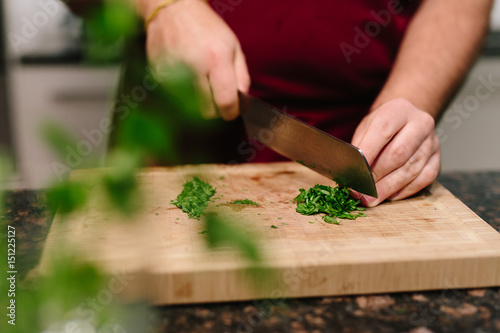 Cutting chive on wooden plate