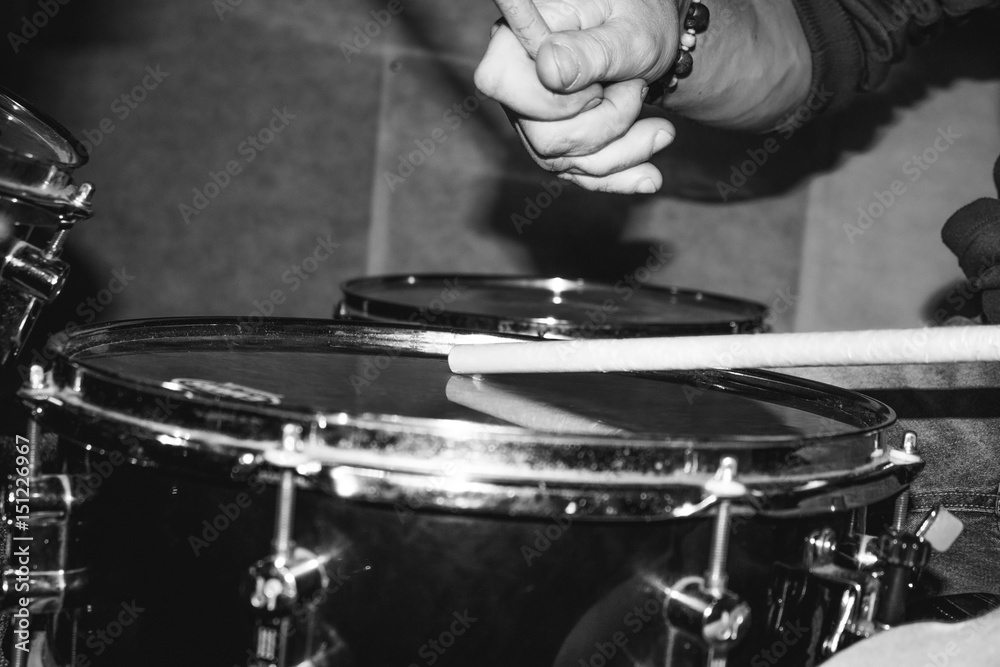 Obraz premium Hand of drummer with sticks and drums, close-up black and white