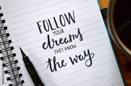 FOLLOW YOUR DREAMS THEY KNOW THE WAY handwritten in notebook