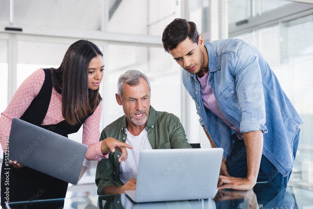 Business people discussing over laptops Business people discussing over laptops
