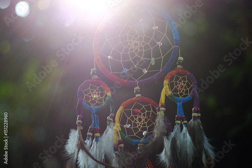 Soft focus Dream Catcher with a flare from the sun set on the background bokeh nature. Native american dream catcher. (Vintage style) boho chic, ethnic amulet.	