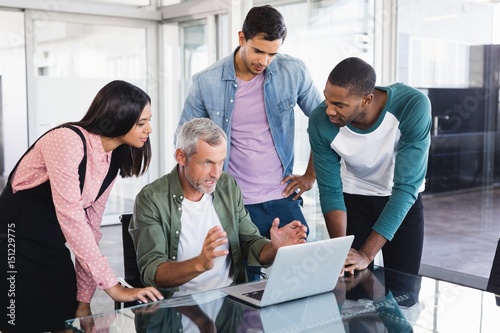 Colleagues looking at businessman at desk