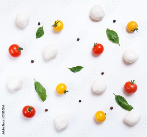 Red and yellow cherry tomatoes, cherry mozzarella,fresh basil, black pepper on white background, top pattern