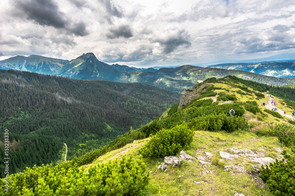 Carpathian mountain range, view on hill in Tatras and hiking trail with people in the distant Carpathian mountain range, view on hill in Tatras and hiking trail with people in the distant