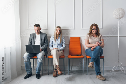Tableau sur toile Group of creative people sitting on chairs in waiting room