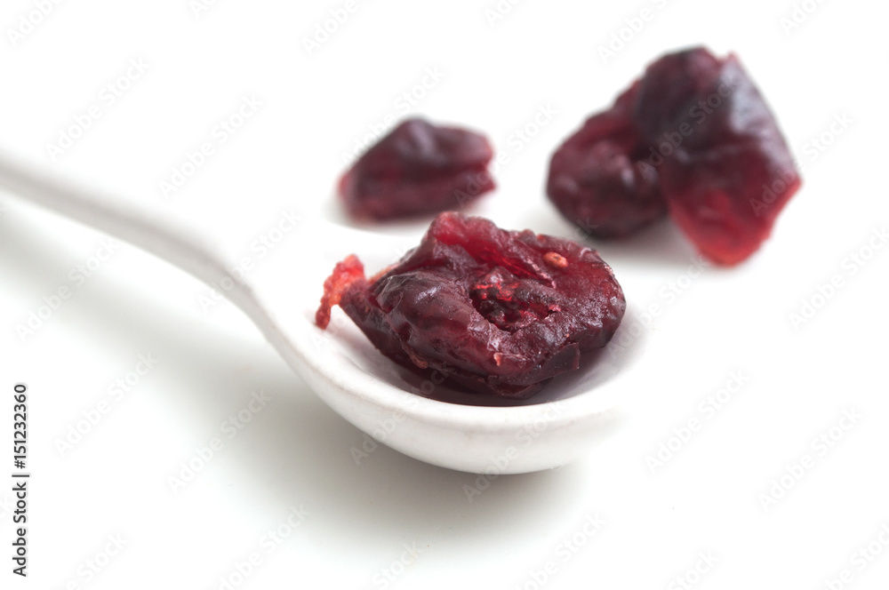 cranberries et petite cuillère sur fond blanc cranberries et petite cuillère sur fond blanc