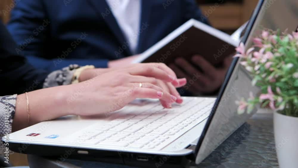 Hands typing on the keyboard in a summer cafe Hands typing on the keyboard in a summer cafe