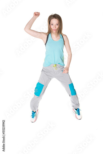 Young, pretty natural looking girl in sport t -shirt and jogging pants having fun dancing. Full body studio shot, pure white background.