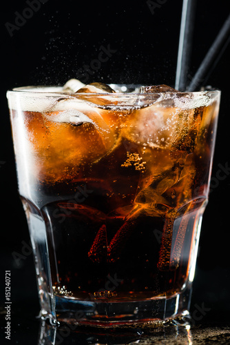 Refreshing drink of cola and ice in a glass