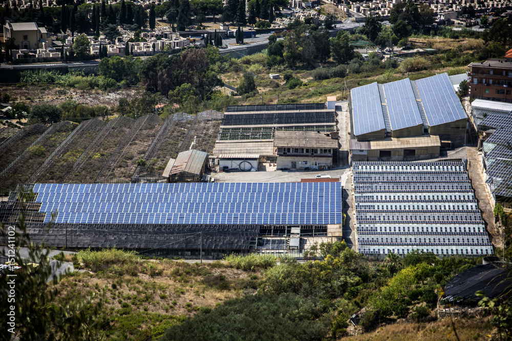 Greenhouse and factory with solar panels on roof, aerial view