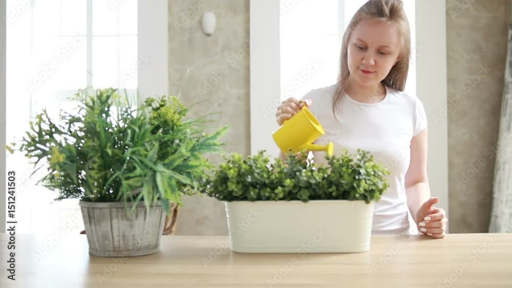 Smiling girl watering plants Smiling girl watering plants
