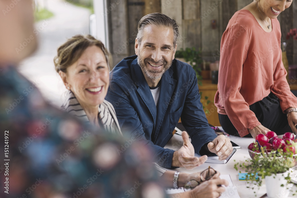 Happy business people looking at colleague during meeting in portable office truck Happy business people looking at colleague during meeting in portable office truck