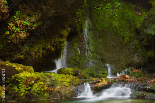 waterfall among rocks covered with green moss © Shchipkova Elena