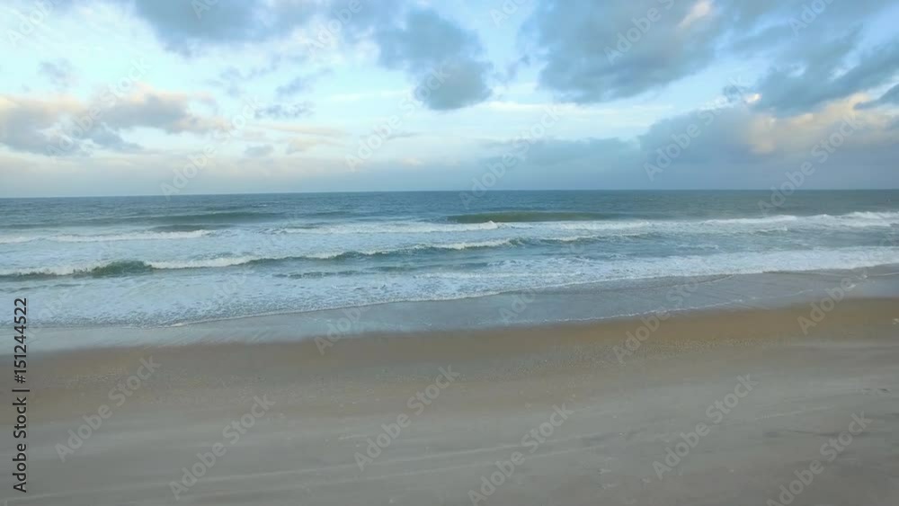 Woman sitting on beach slow rear flyover to ocean Woman sitting on beach slow rear flyover to ocean