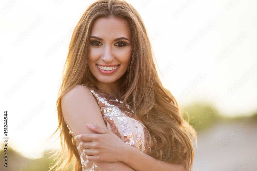 Naklejka premium Beautiful tender woman posing on the sunset beach