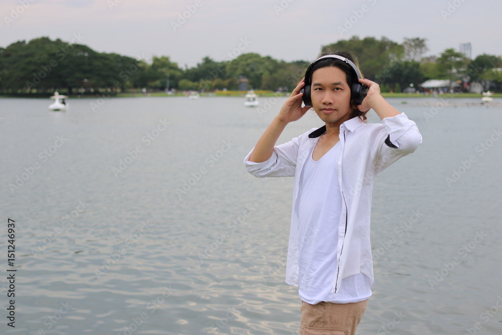 Relax time concept. Happy young hipster against headphones in nature with copy space background. Relax time concept. Happy young hipster against headphones in nature with copy space background.