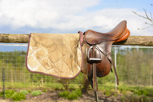 Leather cowboy saddle hanging on the railing