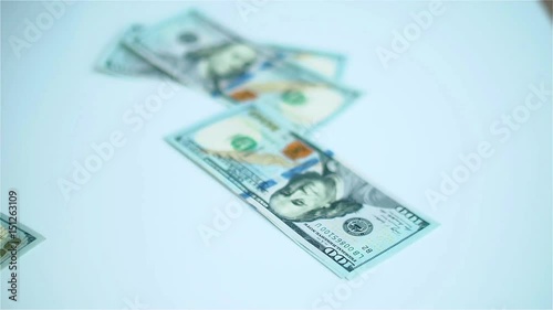 US dollars banknotes falling on white surface. Wages, arnings, winnings.