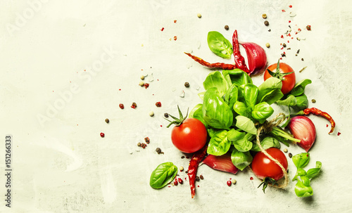 Food background, green basil and tomatoes with spices, top view