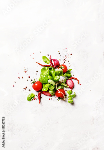 Food background, green basil and tomatoes with spices, top view