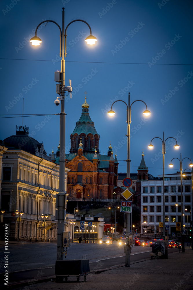 Obraz premium Night descends on Helsinki street with Uspenski Cathedral in background