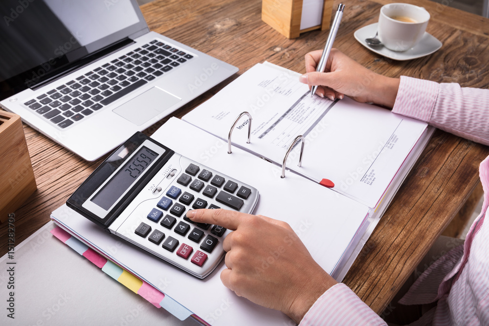 Businesswoman Calculating Tax On Desk Businesswoman Calculating Tax On Desk