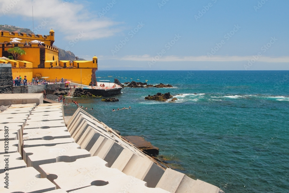 City beach and ancient fortress on ocean coast. Funchal, Madeira, Portugal