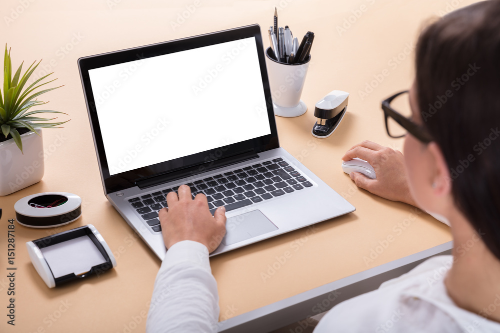 Businesswoman Using Laptop At Office Desk Businesswoman Using Laptop At Office Desk