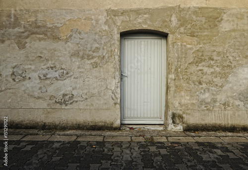 Graue Mauer mit Tür auf dem Land