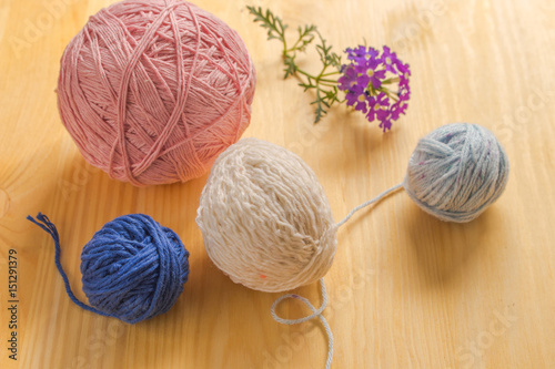 Yarns for knitting on a wooden table.